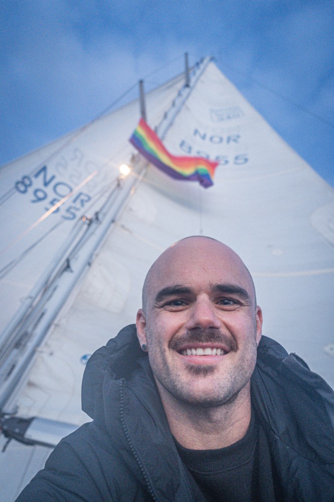 Tomás Salem smiling in front of Falkor's mainsail