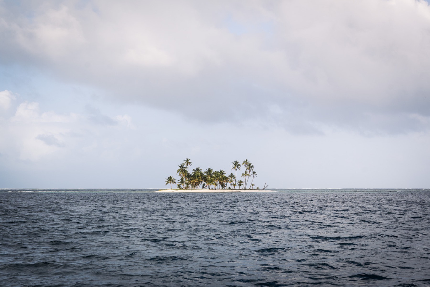 A small palm island alone on the open sea
